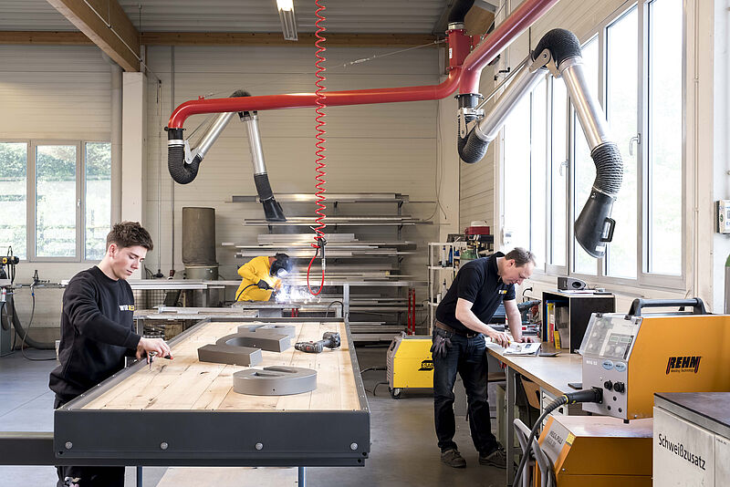 Junger Mitarbeiter von WIR DREI in einer Werkstatt bei Gebrauch von nachhaltigen Werkstoffen.