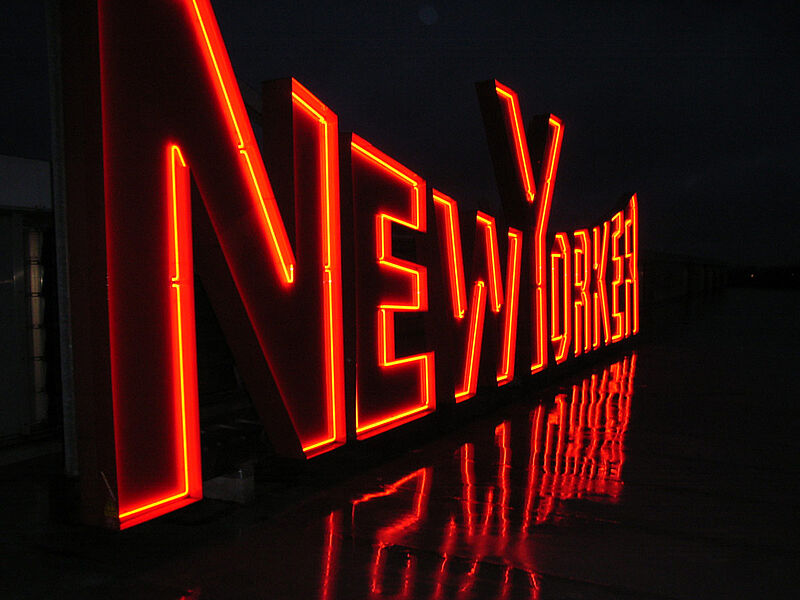 Rotes Neonlogo der Marke NewYorker im Dunklen.