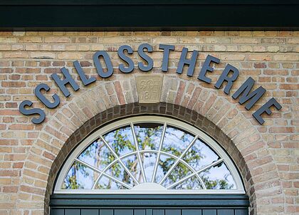 Luxurioese Gebaeudebeschriftung der historischen Schlosstherme.